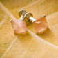 "Silver stud earrings with shimmering peach stones"