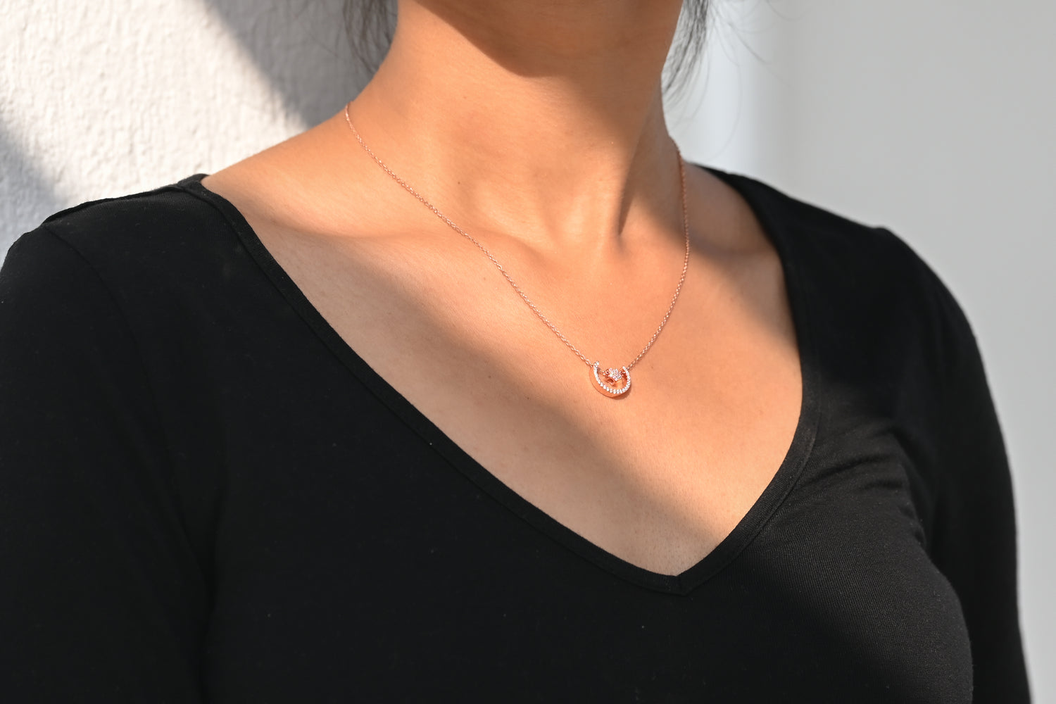 "Influencer adorned with a dainty rose gold necklace, adding a touch of elegance to their outfit."